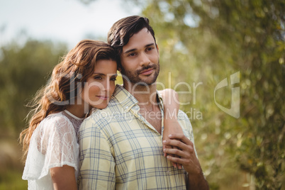 Loving young couple standing together at farm