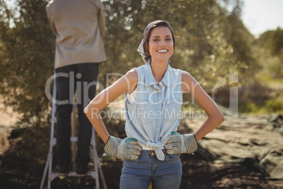 Smiling woman with man in background at olive farm