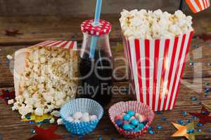 Popcorn, sweet food and cold drink decorated with 4th july theme