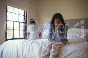 Couple ignoring each other in bedroom