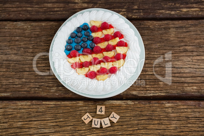 Date blocks and fruitcake on wooden table with 4th july theme