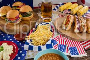Hot dogs and burgers on wooden table with 4th july theme