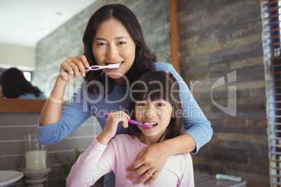 Mother and daughter brushing teeth in the bathroom