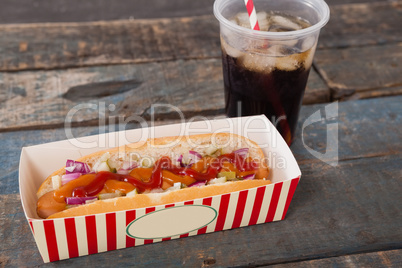 Hot dog and cold drink on wooden table
