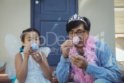 Father and daughter in fairy costume having a tea party