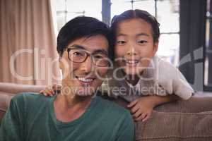 Portrait of smiling father and daughter together in living room