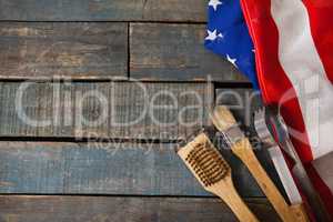 Basting brush and tong with American flag on wooden table