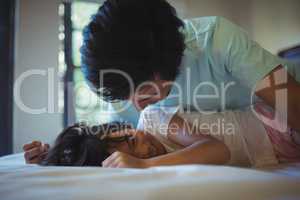 Father and daughter having fun on bed in bed room