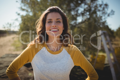 Smiling woman standing at olive farm on sunny day