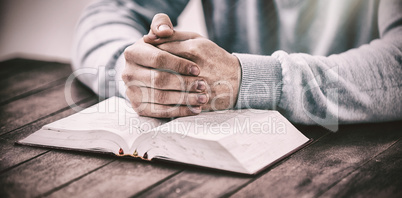 Man with bible praying at desk