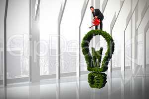 Composite image of businessman watering with red can