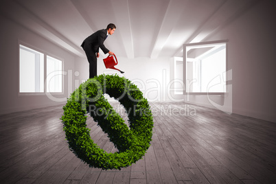 Composite image of businessman watering with red can