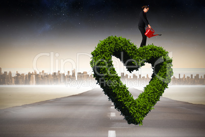 Composite image of businesswoman using red watering can