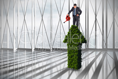 Composite image of mature businessman using watering can