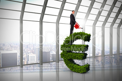 Composite image of businessman holding red watering can