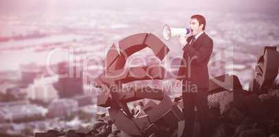 Composite image of standing businessman shouting through a megaphone