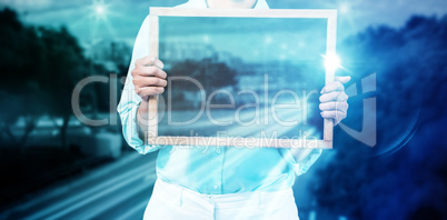 Composite image of mid section of businesswoman holding blank slate