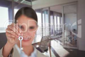 Composite image of close up of businesswoman showing new house key