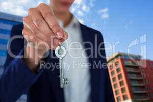 Composite image of mid section of businesswoman showing house key