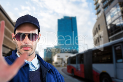 Composite image of confident security officer showing stop gesture
