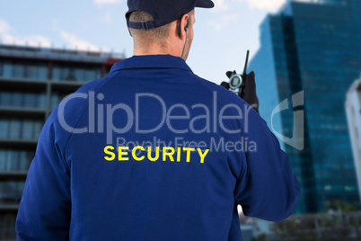 Composite image of rear view of security officer talking on walkie talkie