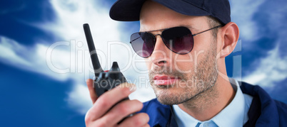 Composite image of close up of security officer talking on walkie talkie