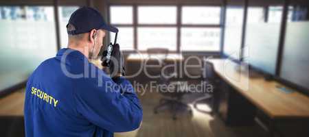 Composite image of rear view of focused security officer talking on walkie talkie