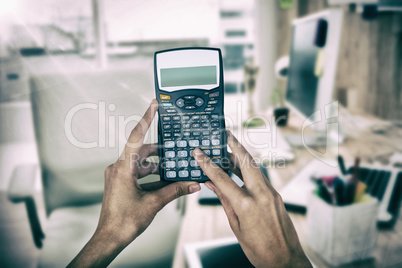 Composite image of cropped hands of businesswoman using calculator