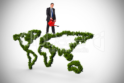 Composite image of businessman holding red watering can