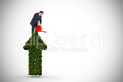 Composite image of mature businessman using watering can