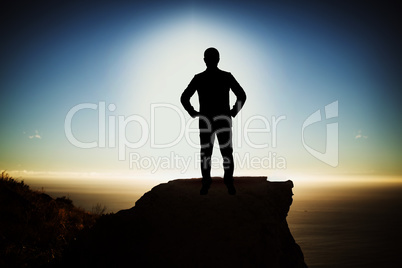 Composite image of silhouette businessman with hand on hip