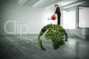 Composite image of businesswoman using red watering can