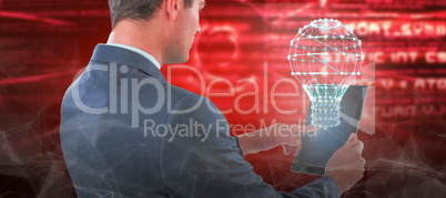 Composite image of businessman using tablet