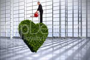 Composite image of businesswoman using red watering can