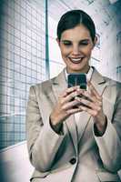 Composite image of smiling businesswoman using mobile phone