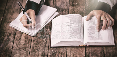 Woman with bible and writing on notepad