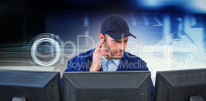 Composite image of security officer listening to earpiece while using computer at desk