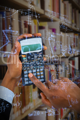Composite image of hands of businessman using calculator