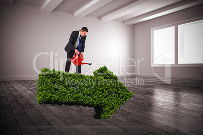 Composite image of businessman holding red watering can