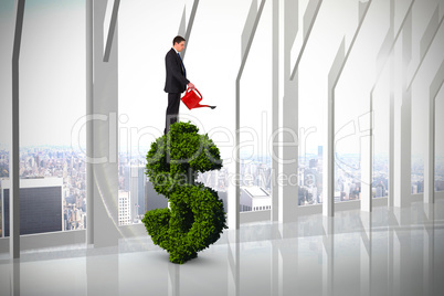 Composite image of businessman holding red watering can