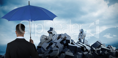 Composite image of rear view of businessman carrying blue umbrella