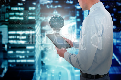 Composite image of businessman looking at digital tablet