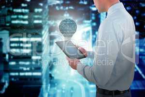 Composite image of businessman looking at digital tablet