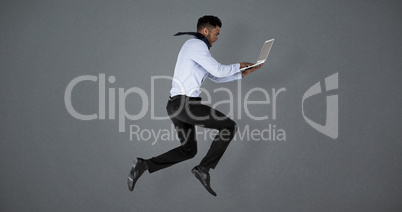 Composite image of businessman using laptop while jumping