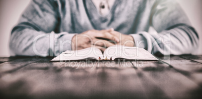 Man with bible praying on table