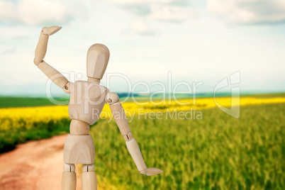Composite image of wooden 3d figurine standing with hand raised