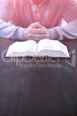 Man with bible praying at table