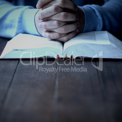 Mid section of man with bible praying