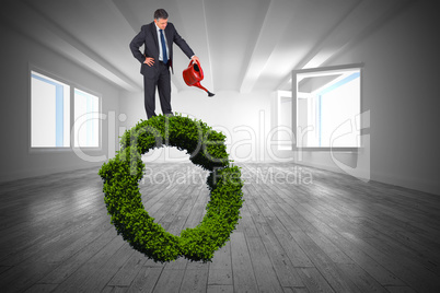 Composite image of mature businessman using watering can