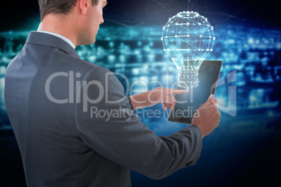 Composite image of businessman using tablet